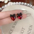 Close-up of elegant red heart stud earrings with black bow detail and cubic zirconia - Bowknot Heart / Red Black