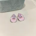 Close-up of pink pear-shaped zircon stud earrings with enamel finish and silver needles - Pink