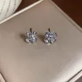Close-up of sparkling zircon flower stud earrings in a brilliant four-leaf clover design - White