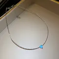 Macro view of a blue heart-shaped pendant on a textured silver-toned clavicle chain - Necklace - Silver - Blue