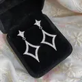 Detailed macro view of sparkling zirconia star earrings displayed in a black velvet jewelry box - Earrings / Silver
