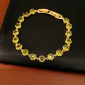 Close-up detail of an 18k gold-plated bracelet featuring round green zircon stones. - Gold Green