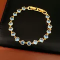 Detailed macro shot of 18k gold plated bracelet featuring round blue zircon stones - Gold Blue