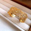 Detailed macro view of golden lace texture cuff bracelet with elegant embedded crystals - Style 6