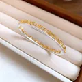 Close-up detail of a gold lace texture bangle with sparkling crystals in a velvet tray - Style 2