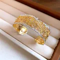 Macro detail of French style bicolor lace texture open bangle with small diamond accents - Style 4