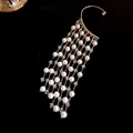 Close-up of elegant vintage pearl and crystal tassel ear cuff on deep black background - Single Piece / Silver