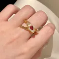 Detailed close-up of a vintage adjustable gold snake ring with a red teardrop stone - Ring / Gold