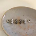 Detailed view of silver hoop earring set with pearls and braided textures on a plate - 4# Pearl/Woven Style