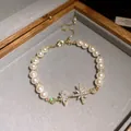 Close-up of pearl bracelet featuring sparkling 18k gold plated zircon star charms - Gold