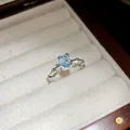 Gros plan détaillé d'une bague en zircon bleu clair dans une boîte à bijoux en velours - Argent-Bleu