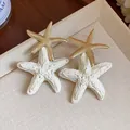 Detail showing the intricate raffia texture and golden finish on starfish earrings. - Single Starfish Style (HE31348) / Gold+White