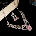 Vue détaillée de la parure en zircon rose avec collier et boucles d'oreilles sur fond noir - Argent-Rose