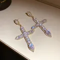 Close-up of luxury cross drop earrings encrusted with sparkling cubic zirconia stones - Golden Cross Style (47#)