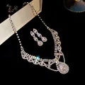 Vue détaillée du collier et des boucles d'oreilles en zircone étincelante sur fond noir - Argent-Transparent