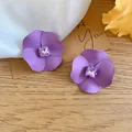 Close-up of elegant purple matte flower stud earrings featuring a square rhinestone center - Purple