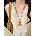 Close-up detail of a handmade bohemian woven flower pendant with a natural wooden bead. - Five-Petal Flower Woven Style (HN12227) / Brown