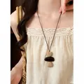 Detail shot of bohemian woven long necklace with natural accents and leather cord. - Heart Woven Style (HN12228) / Brown