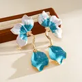 Detailed macro view of blue and white enamel flower petals on golden earrings - Steel Post Style (HE34222) / Blue