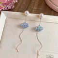 Primo piano di orecchini a forma di nuvola blu cangiante con lunghe nappe argentate sottili. - Perno in Argento - Bianco - Blu