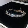 Primer plano de una pulsera brillante de tres capas con pedrería sobre terciopelo - 26# Pulsera