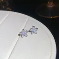 Macro view of sparkling five-petal zircon flower stud earrings in a silver finish - Flower Stud Earrings (HE32572) / Silver