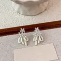 Exquisite white enamel bow earrings with floral crystal studs in a premium setting. - Silver Needle / White