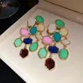Detail showing vintage gold-tone earrings with multi-colored geometric resin stones - Tassel Studs / Gold Multicolor