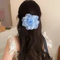 Detailed rear view of a blue gradient fabric rose hair clip on long wavy brown hair - Duckbill Hair Clips / Blue
