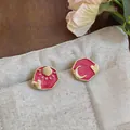 Detail of asymmetrical pink enamel earrings featuring sun, moon, and heart motifs. - Sun And Moon Heart Style (HE32630) / Gold and Rose Red