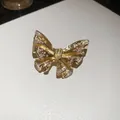 Close-up view of a luxury gold-toned butterfly brooch with sparkling crystals - Butterfly Design / Gold