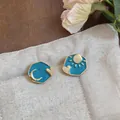 Macro view of asymmetric enamel stud earrings featuring sun, moon, and heart designs - Sun And Moon Heart Style (HE32630) / Gold & Blue