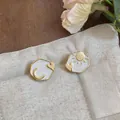 Close-up of asymmetric sun and moon enamel stud earrings on a linen texture background. - Sun And Moon Heart Style (HE32630) / Gold & White