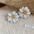 Macro detail of elegant flower stud earrings with white petals and gold-toned center - Steel Needle - White