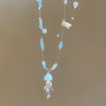 Detailed shot of ocean-themed beaded necklace with light blue jellyfish pendant and shells. - Marine Theme (HN12342) / Silver-Blue