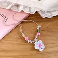 Close-up of 3D cherry blossom pendant and colorful beads on a sweet floral necklace - Pink