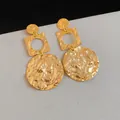 Close-up of gold-plated geometric earrings with a hammered wrinkled texture finish - Hammered Geometric Round Style (HE34439) / 1 Pair Pack / Gold
