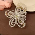 Detailed view of elegant white pearl flower hair claw clip with a clear plastic base - White