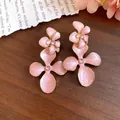 Exquisite detail view of pink enamel flower earrings with sparkling crystal centers. - Pink