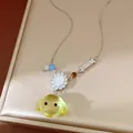 Dettaglio della collana con cane in resina gialla e osso con zirconi brillanti - Giallo