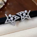 Macro view of elegant star shaped stud earrings featuring sparkling zircon and white pearls - Star / Silver