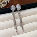 Macro detail of silver tassel earrings with floral zircon accents on a velvet tray. - Flower Style (2#) / Silver