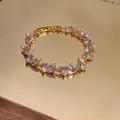 Dettaglio di un elegante bracciale placcato oro con zirconi marquise viola e chiari - Oro-Rosa