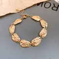 Primer plano detallado del acabado martillado de una pulsera de eslabones ovalados dorados - Pulsera / Dorado