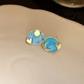 Detailed view of vintage blue enamel sun and moon stud earrings with gold heart accents - Silver Needle - Rose Red