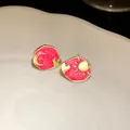 Detailed close-up of gold-plated enamel sun and moon stud earrings with heart detail - Silver Earring Post-Blue