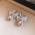 Detailed view of cute flocked bear earrings with heart-shaped crystal and clear backing. - White-Coffee