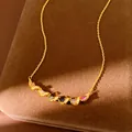 Detail view of a gold-plated necklace featuring a twisted pendant with colorful zircons. - Colored Zirconia Twisted Pendant Necklace / Gold-Multicolor