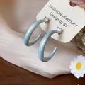Primer plano de pendientes de esmalte azul claro en forma de C con detalle de circón. - Pequeño / Azul