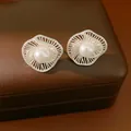 Vista dettagliata di eleganti orecchini a lobo in argento a forma di fiore con perla bianca - Perno in Argento Fiore Intrecciato (HE33830) / Bianco